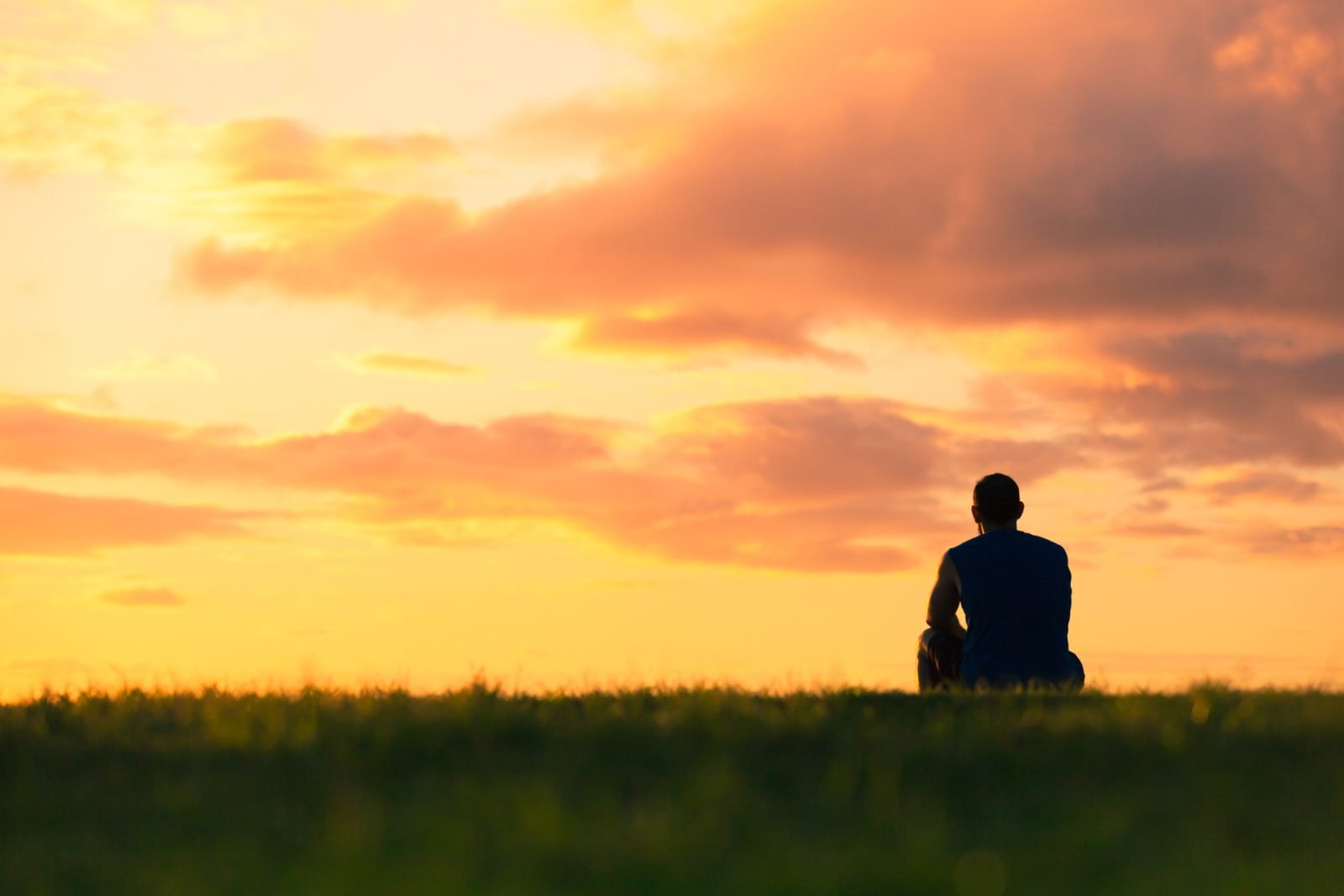 Image of someone sitting in front of a sunset